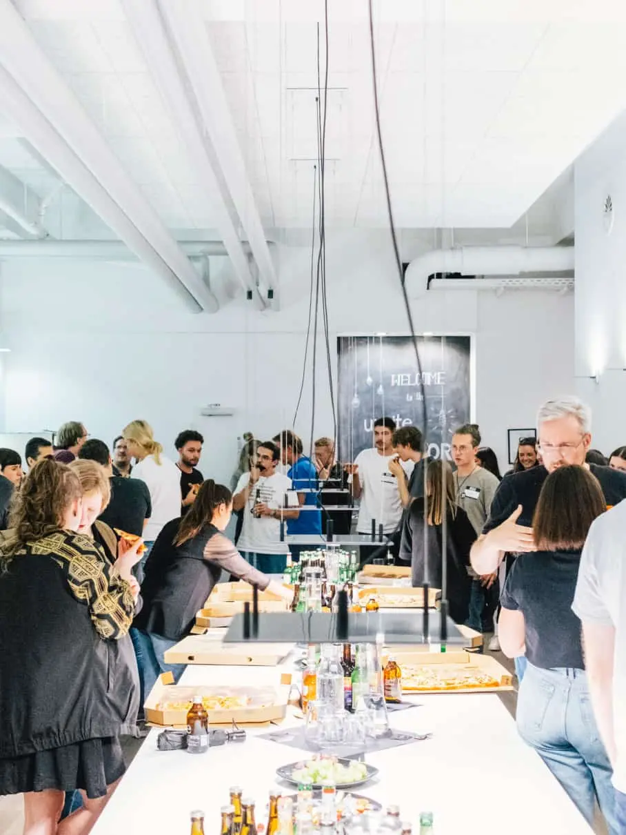 Viele Gäste in der Küche beim gemeinsamen “Get together” mit Pizza und Drinks bei der UXnite zu Inclusive Design im Stuttgarter 21TORR Office.